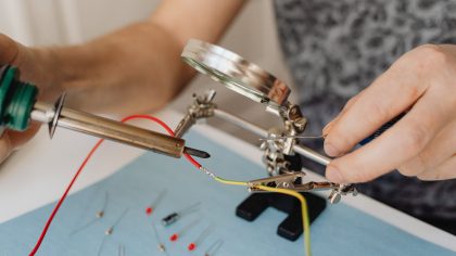 a person holding a soldering iron